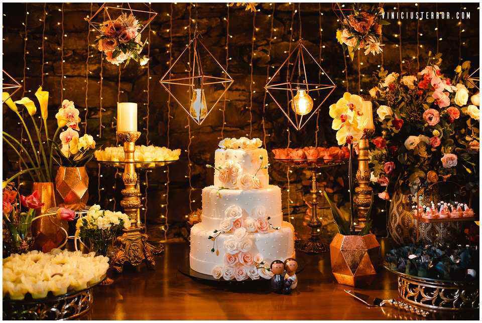 mesa-de-bolo-com-velas-e-arranjos-florais